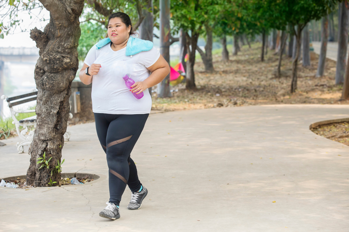 Fat Woman Carrying a Bottle during Jogging